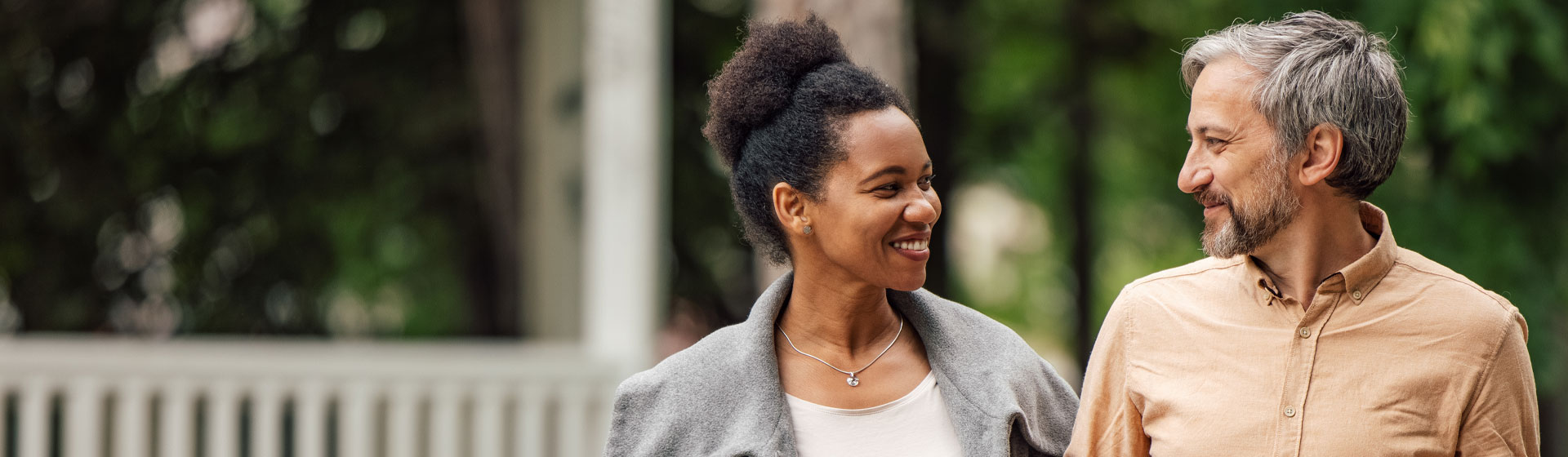 Woman and man smiling at each other outside