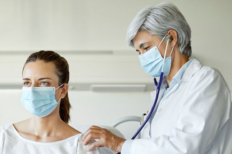 Doctor using stethoscope on patient
